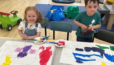 Two of the children, one girl, one boy, are painting pictures.