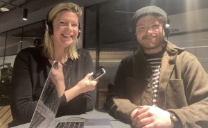 Talking Newspaper volunteers Katy Cowen and Hal Coleman, wearing headphones and holding an audio recorder.