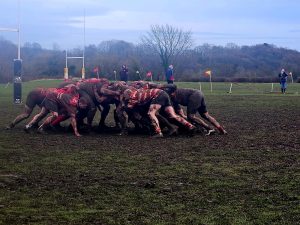 Richmond Veterans Rugby Team scrumming on a muddy rugby pitch.