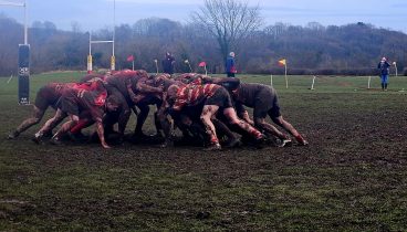 Richmond Veterans Rugby Team scrumming on a muddy rugby pitch.